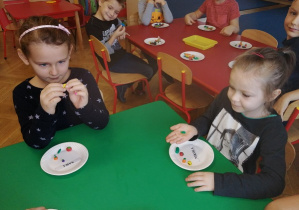 Dzieci siedzą przy stoliku i lepią z plasteliny